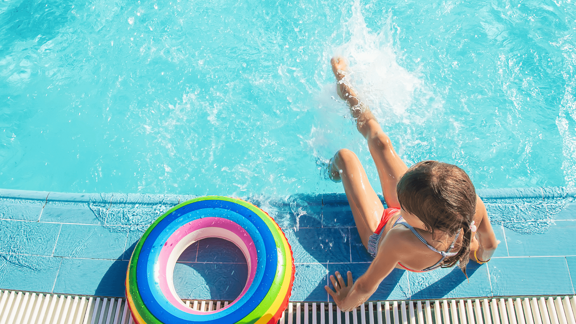 Child sitting on pool ledge